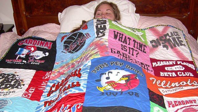 Girl snuggled under T-shirt quilt