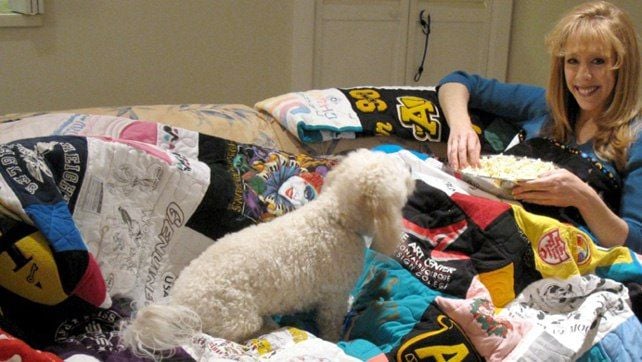 Dog and woman eating pop corn under a Too Cool T-shirt Quilt