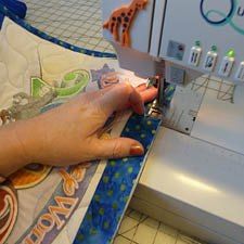 Binding a T-shirt quilt on a sewing machine.