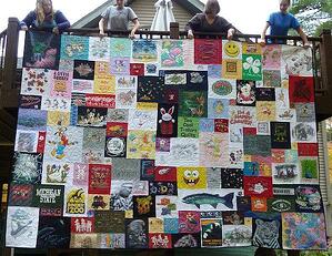 This is one of the worlds's largest T-shirt quilt photographed hanging over a deck railing.