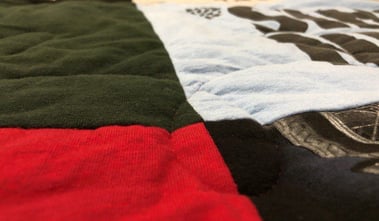 A T-shirt quilt made with high loft batting. The low areas are where the stitching is and the high areas are where there is no stitching. 