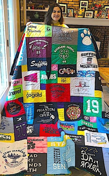 Girl with graduation quilt standing in front of fire place