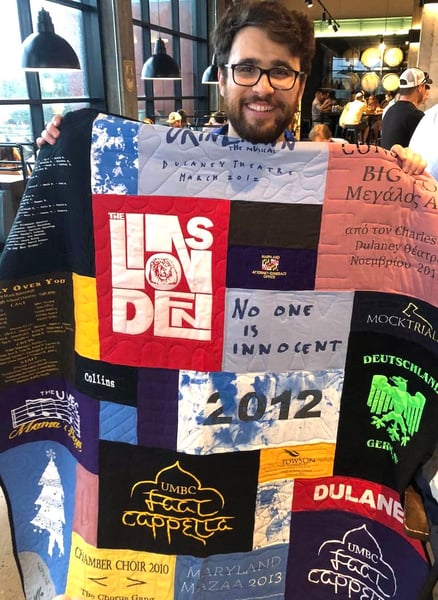 Man holding quilt in restaurant by Too Cool T-shirt Quilts