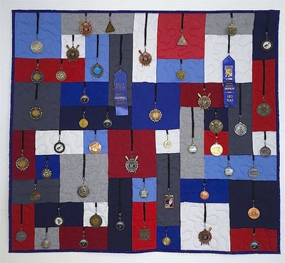 Medals hanging on a quilt.