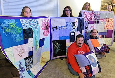 A family with their Memorial quilts and pillows by Too Cool T-shirt Quilts