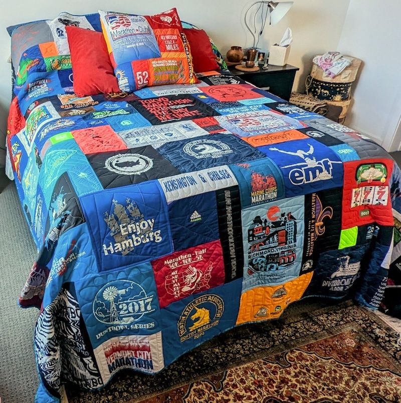 Runners quilt and pillow on bed by Too Cool T-shirt Quilts