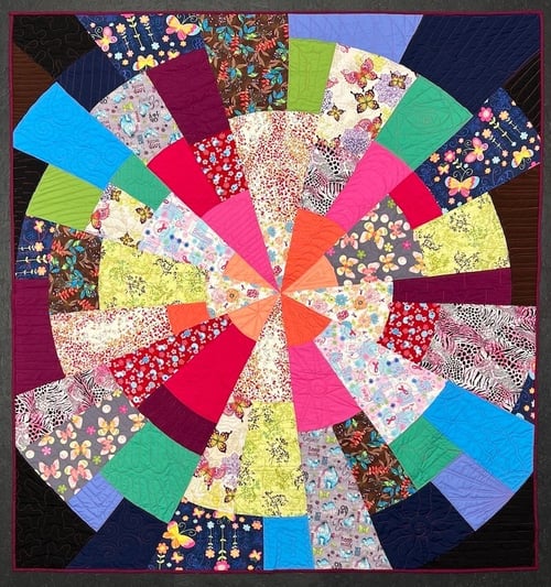 a quilt made from scrubs in the ultra modern Kaleidoscope style by Too Cool T-shirt Quilts
