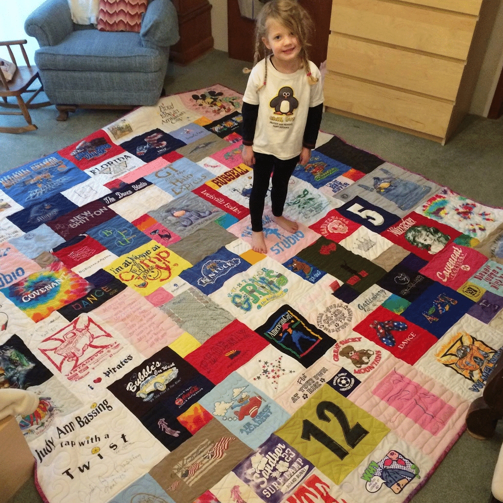 Cute little girl on a T-shirt quilt by Too Cool T-shirt Quilt