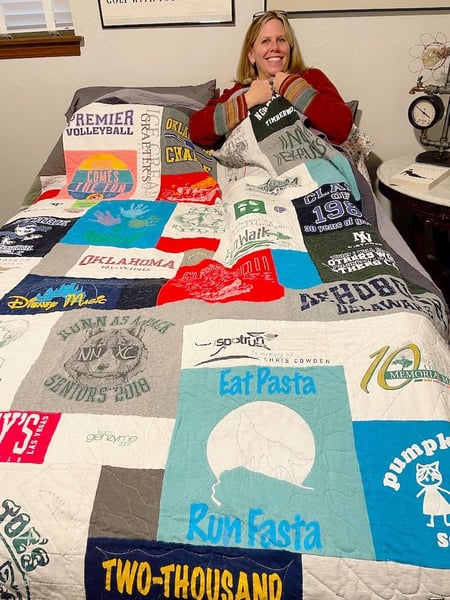 Woman under covers of a Too Cool T-shirt Quilt