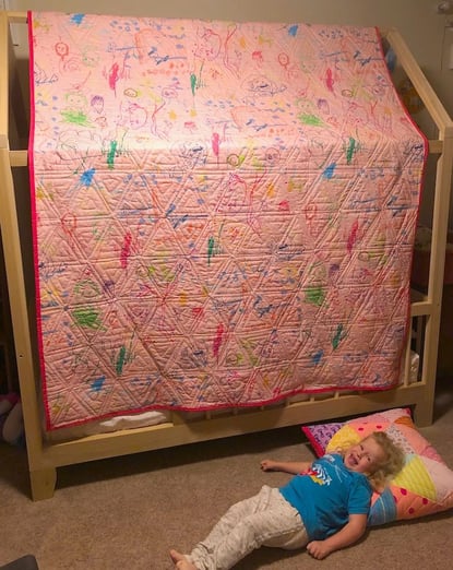 back of triangle quilt with girl and pillow