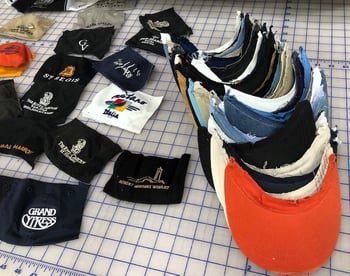 getting baseball caps ready to put into a T-shirt quilt. First, remove the bills.