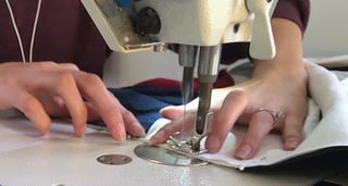 Close up of a person sewing a T-shirt quilt.