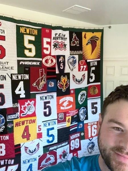 hockey quilt hanging on the wall by Too Cool T-shirt Quilts