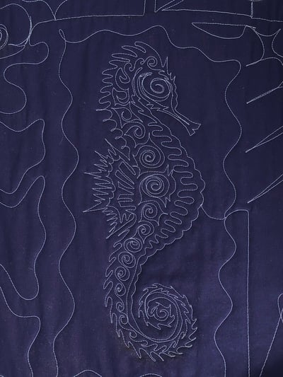 The back of a T-shirt quilt with a sea horse that has been traced.
