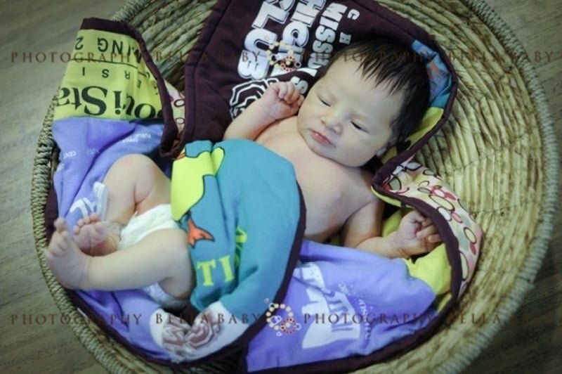 they made it - baby in basket with T-shirt quilt