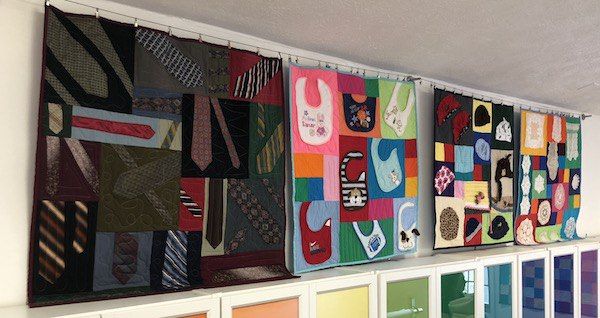 row of mini quilts hanging here at too cool